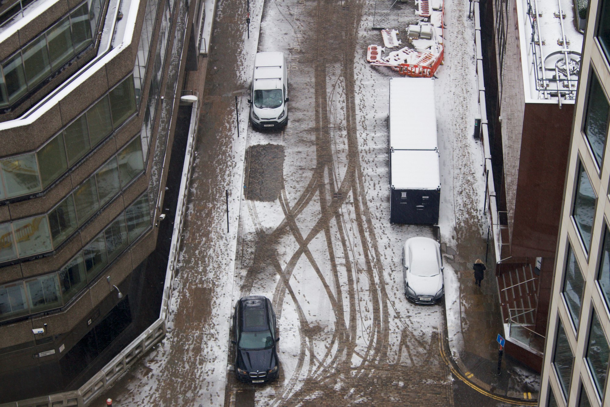 Looking down on snowy city streets of London cars made tracks in snow